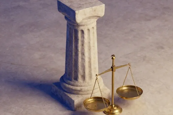 Columna firme junto a una balanza sencilla sobre piedra clara