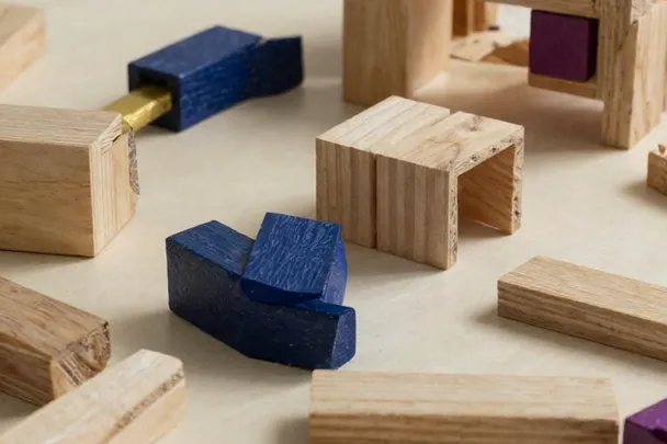 Bloques de madera reordenados sobre una mesa de trabajo.