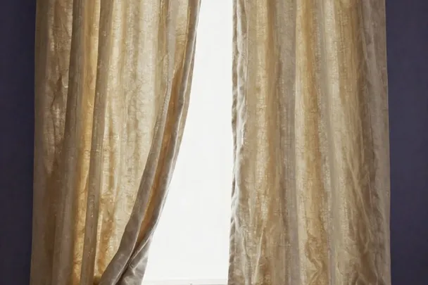 Dos cortinas claras se acercan con la brisa ante una ventana
