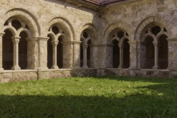 Claustro sencillo de piedra con un patio silencioso.