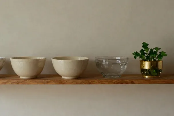 Estantes de madera nivelados con cuencos de cerámica bien separados.