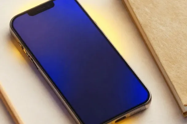 A phone with its screen turned down rests beside a closed notebook and pencil.