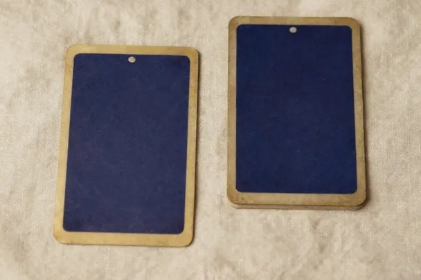 Two tarot cards with plain backs lie beside each other on linen.