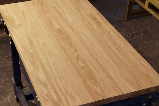 Banco de trabajo firme sostiene una pieza de madera suavemente pulida