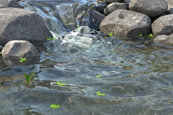 Agua clara que recorre un canal de piedra hacia un jardín.
