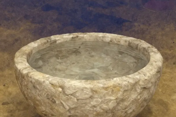 Agua tranquila ocupa una fuente de piedra de líneas sencillas