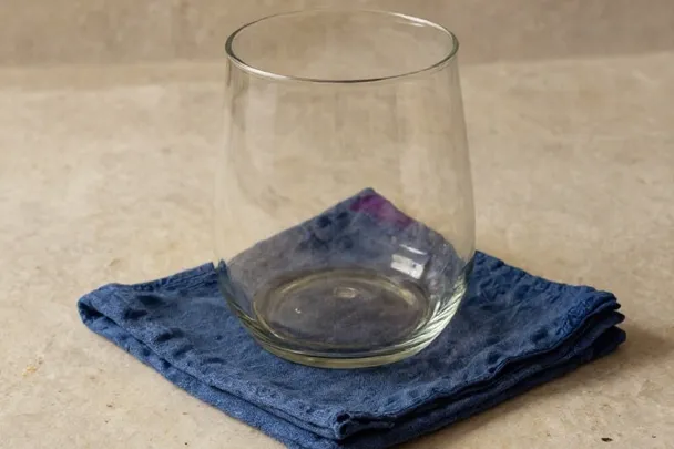 Vidrio transparente y tela azul reposan sobre una superficie equilibrada
