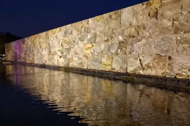 Reflejo ondulado de un muro intacto en agua nocturna.