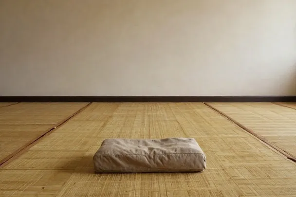 Cojín de meditación sobre esterillas en una sala silenciosa.