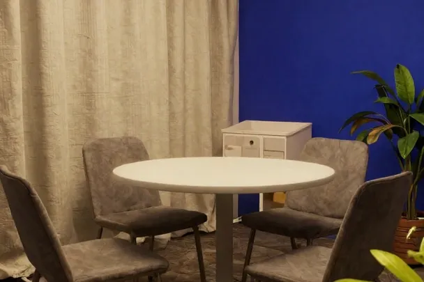 Sillas vacías junto a una mesa en una sala de consulta tranquila.