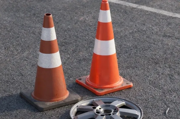 Dos conos lisos y un tapacubos permanecen en una carretera vacía