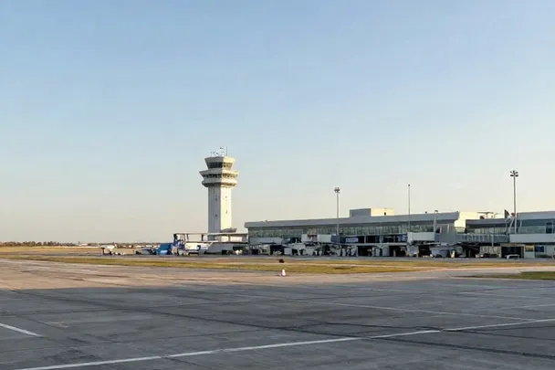 Avión sin marcas espera junto a una pista vacía al amanecer
