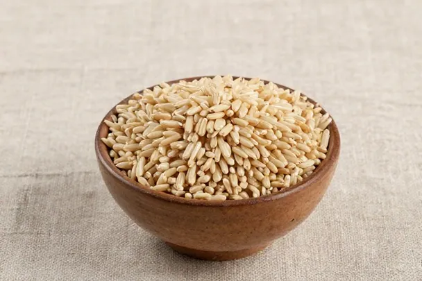 Granos de arroz seco llenan un cuenco de barro