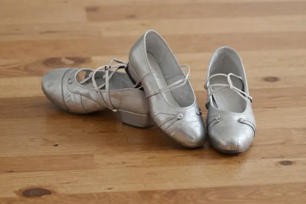 Dos pares de zapatos de baile descansan apoyados sobre el suelo