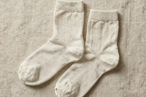 Par de calcetines lisos descansa doblado sobre lino