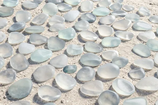 Fragmentos de vidrio de mar pulido descansan sobre arena