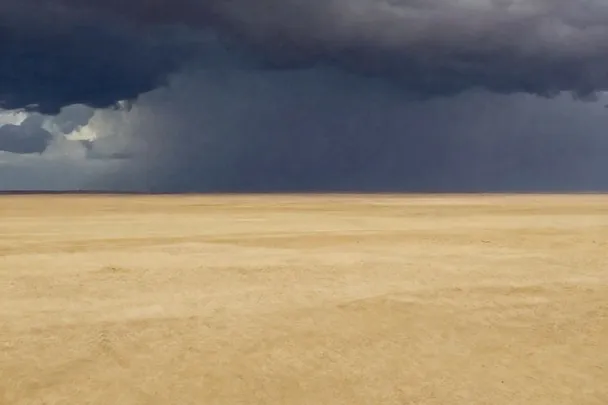 Tormenta lejana oscurece el horizonte de un paisaje intacto