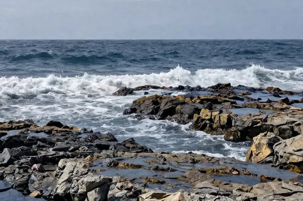 Mar agitado rompe lejos de una costa rocosa y segura