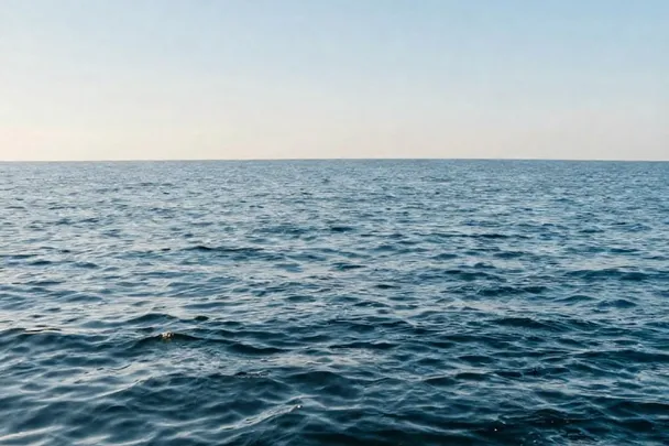 Mar tranquilo refleja la luz suave de la mañana