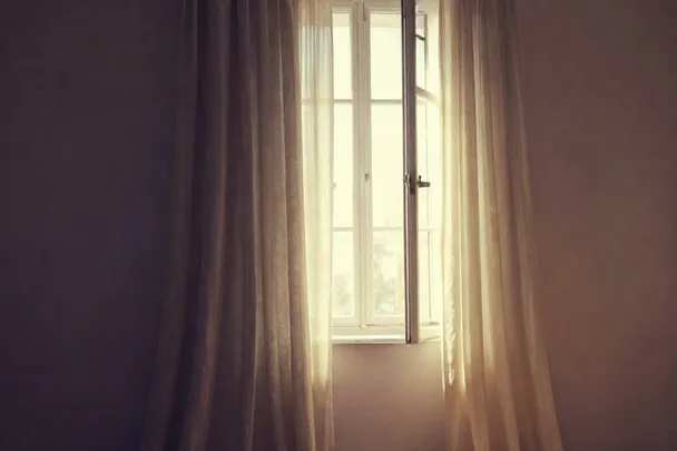 Cortina translúcida se eleva en una habitación vacía y luminosa