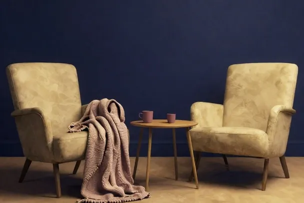 Dos sillones vacíos comparten una manta y una mesa de té