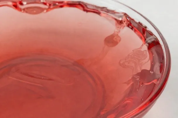 Tinte rojo natural se extiende suavemente en un cuenco de vidrio
