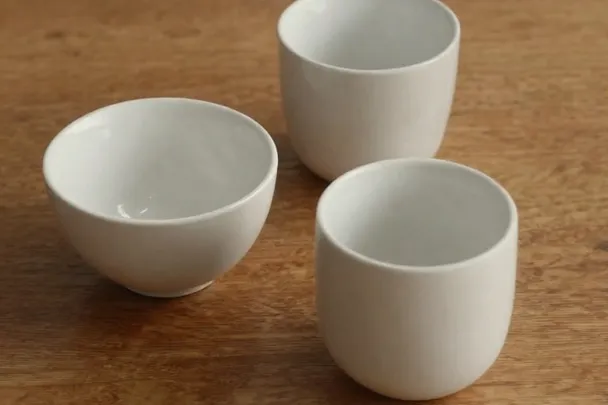 Tres tazas lisas forman un triángulo irregular sobre una mesa