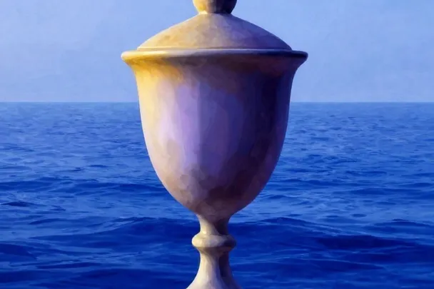Copa de cerámica con tapa reposa en una repisa frente al mar