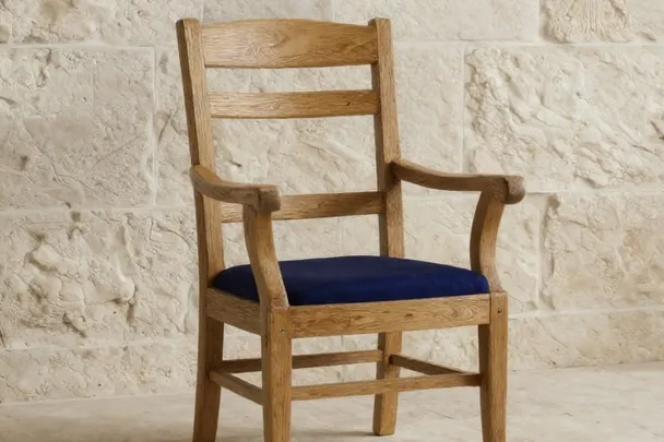 Sillón de madera firme descansa ante un muro de piedra claro