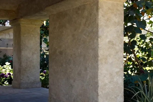 Columna de piedra sencilla sostiene un porche abierto al jardín