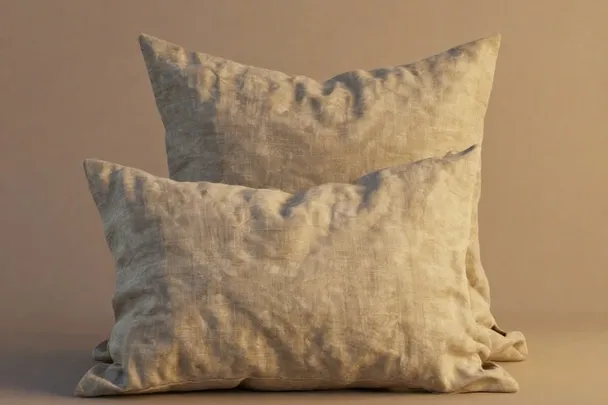 Dos almohadas de lino juntas sobre una superficie neutra.