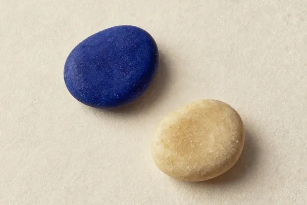 Dos piedras lisas contrastan sobre un paño de lino claro